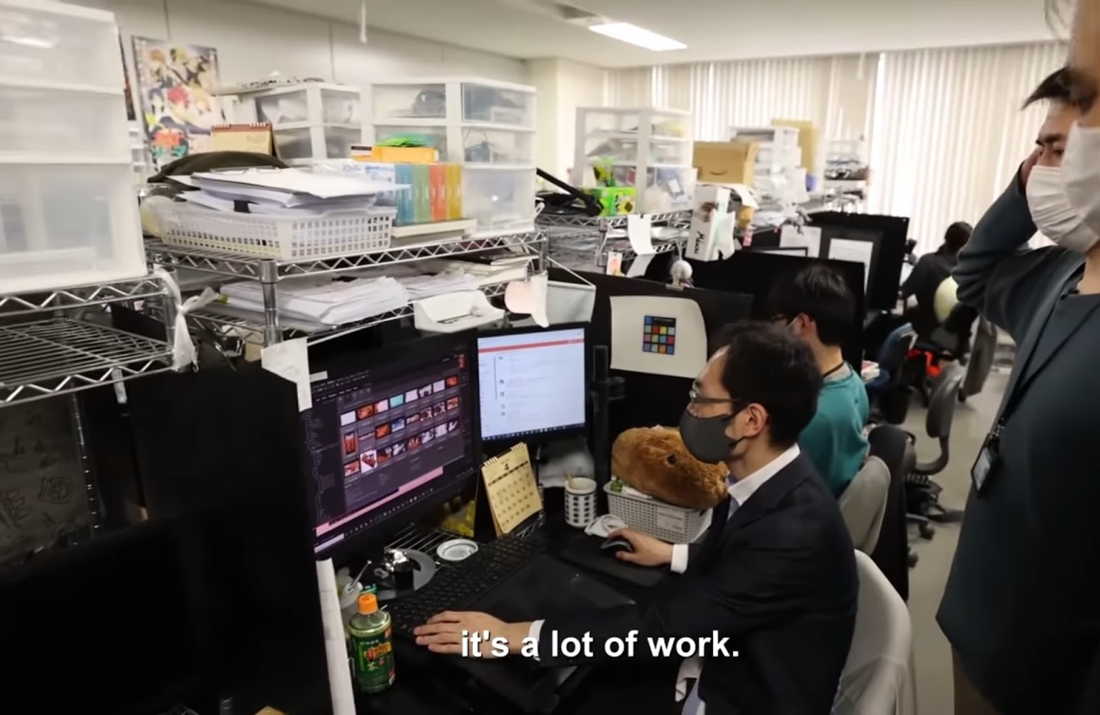 A cluttered animation studio with animators at workstations, and a caption saying "it's a lot of work.
