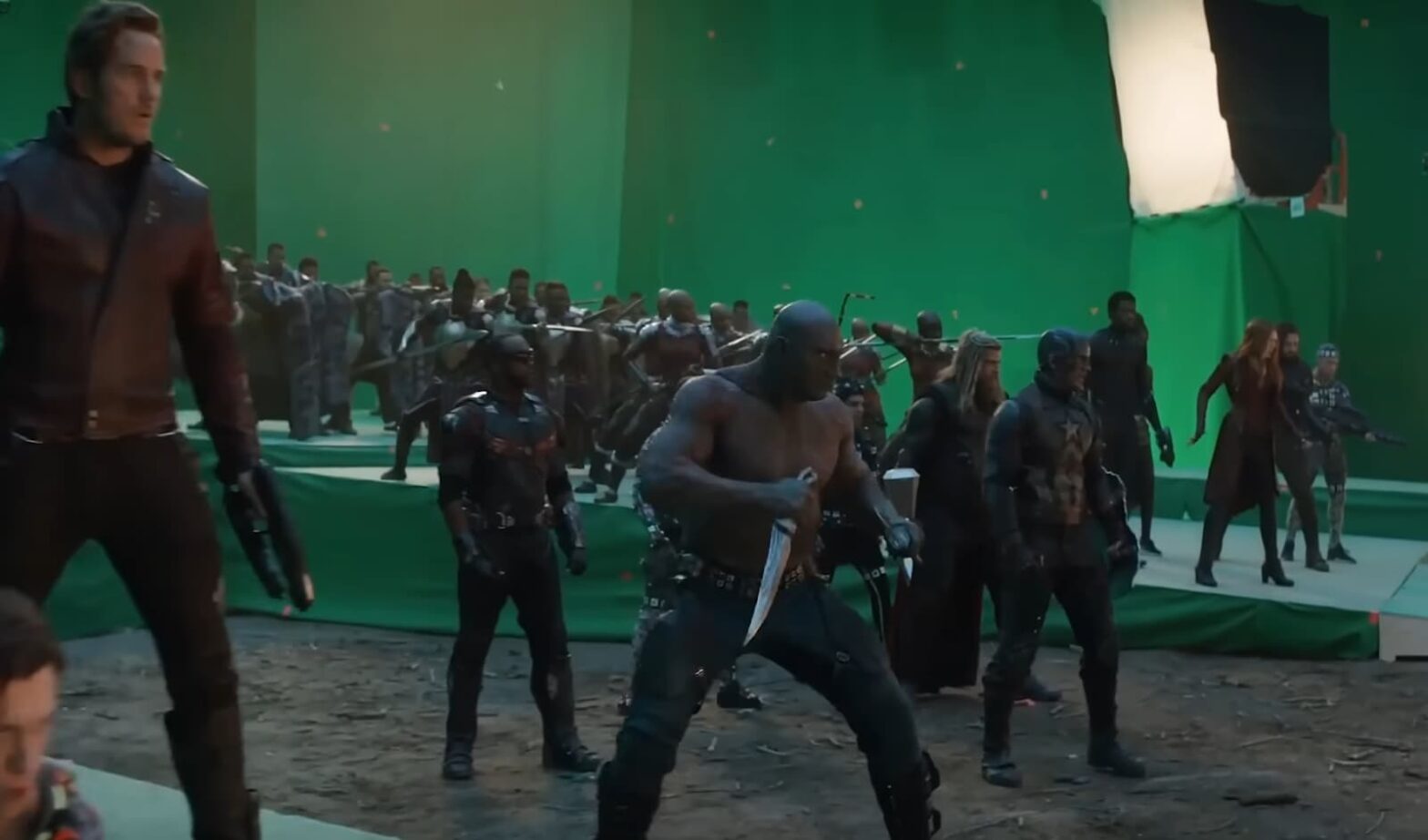 Superheroes prepare for battle on a green screen set