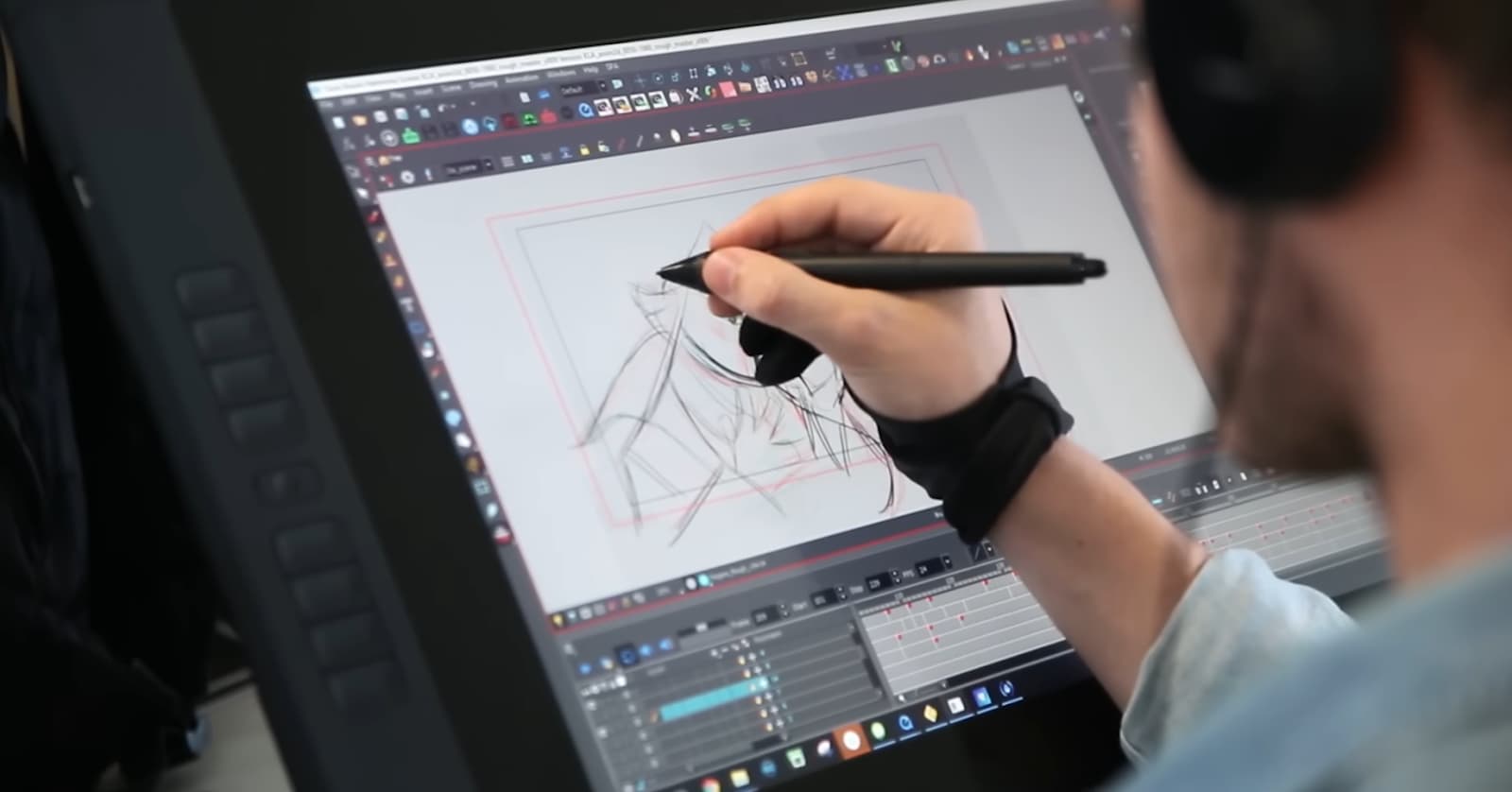 An artist sketching an abstract figure on a graphic tablet with stylus