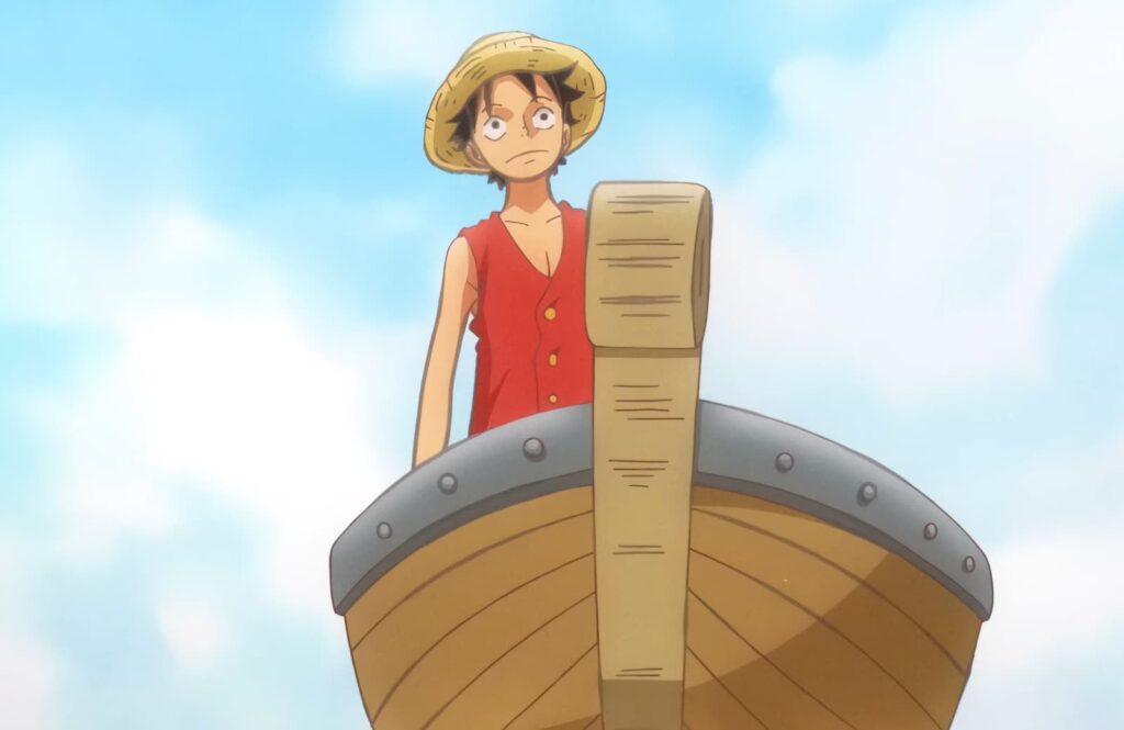 A boy in a straw hat looks surprised atop a large wooden structure