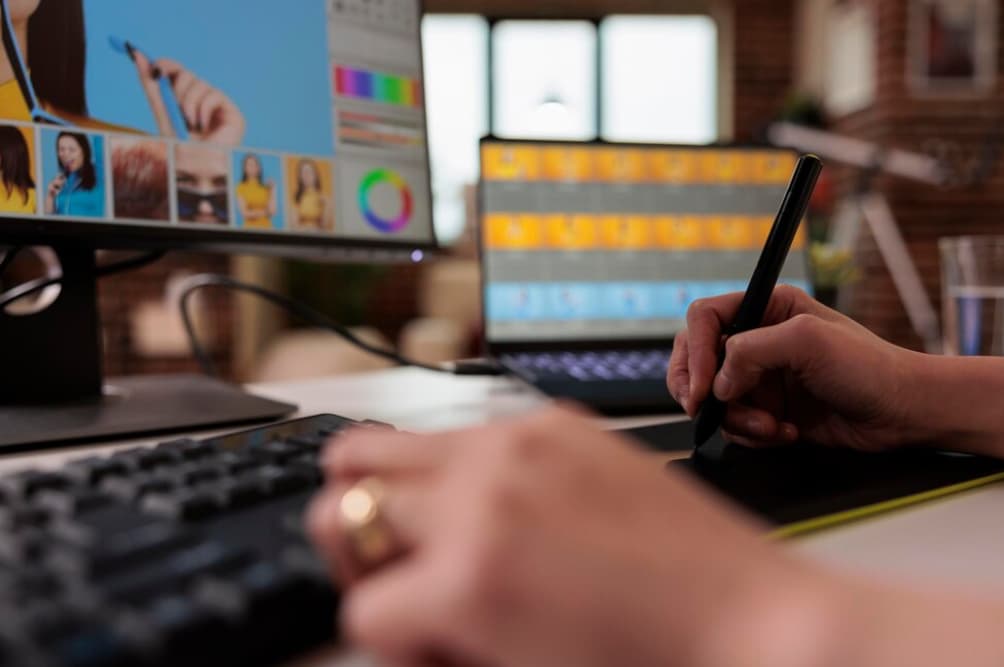 Close-up of hands using a graphic tablet and keyboard with colorful designs